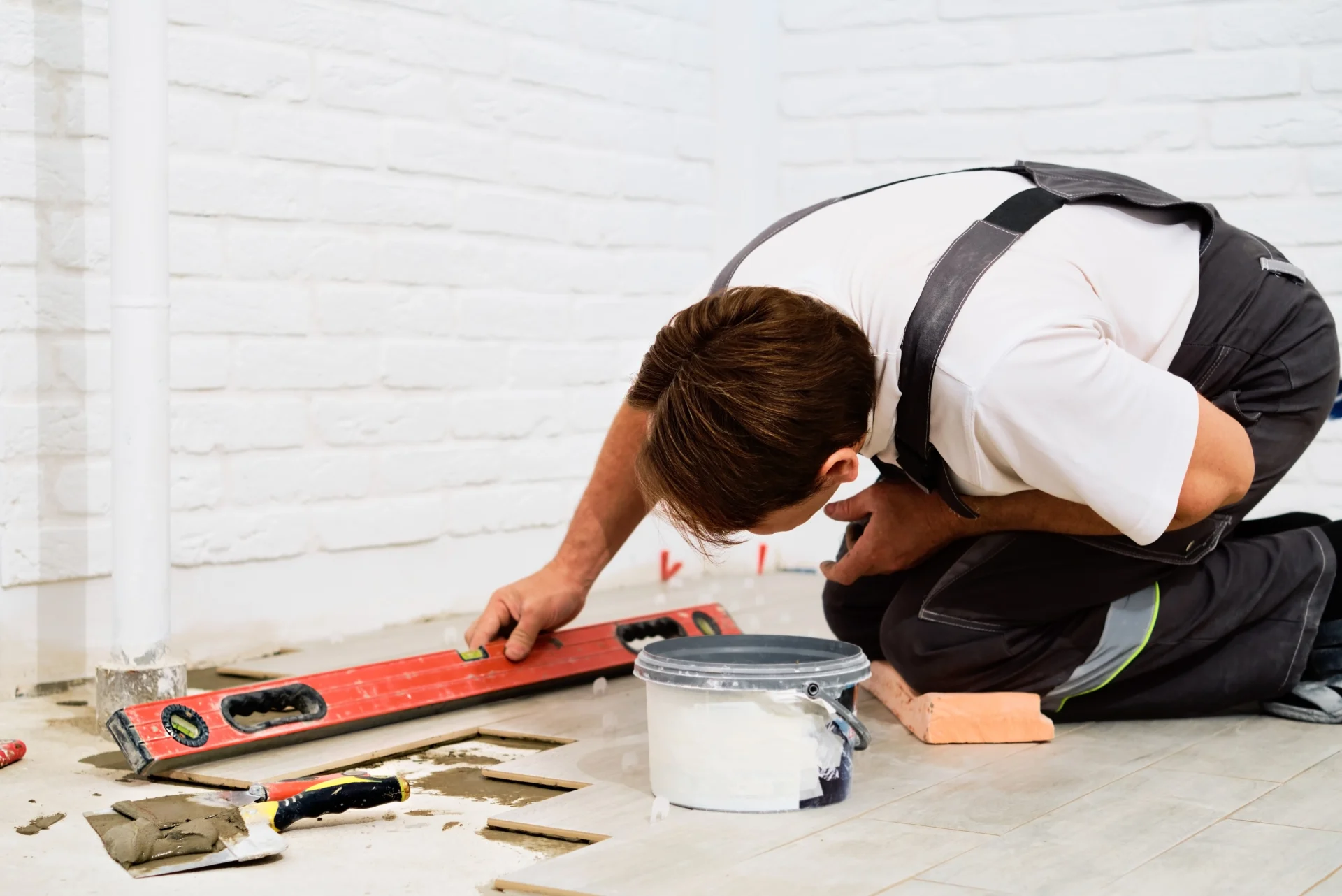 Builder Checks Quality Laid Tiles With Manual Bubble Level Construction Worker Installing Ceramic Floor Tiles Construction Sites Floor Repair Selective Focus